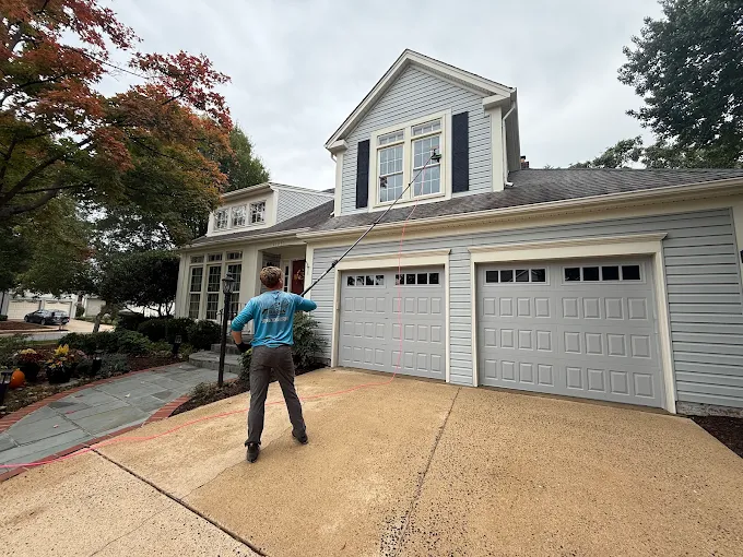 Owner cleaning windows with a water-fed pole system