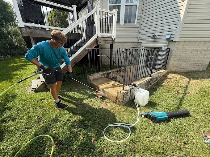 Owner pressure washing a concrete stairwell in Loudoun County, VA